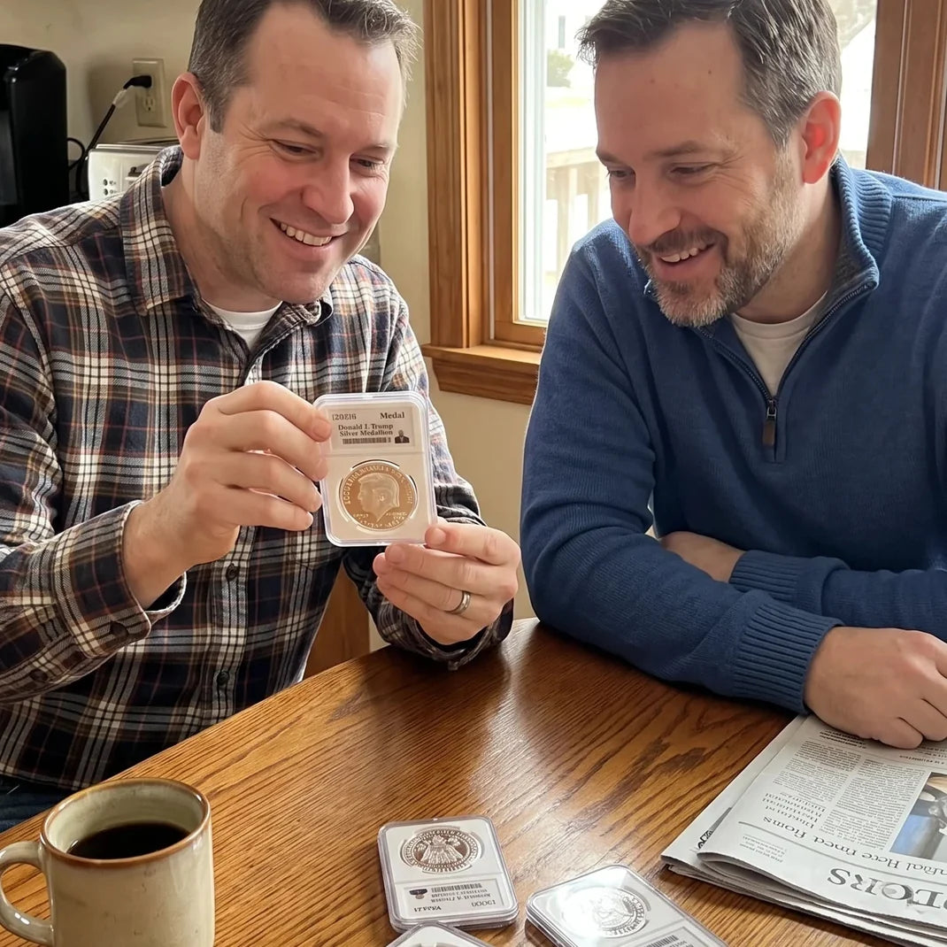 Two men admiring the Trump silver coin at a wooden table