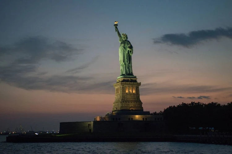 Statue of Liberty at dusk with the skyline
