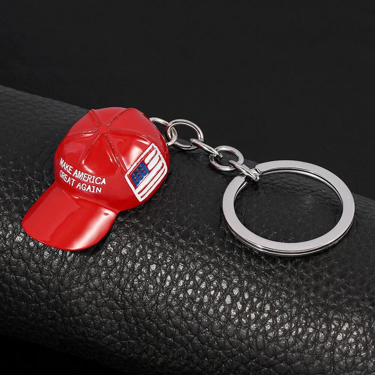 Red MAGA hat keychain on black leather background